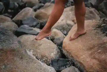 mobile physical therapy Big Island stepping from rock to rock after completing treatments from Kona Mobile PT